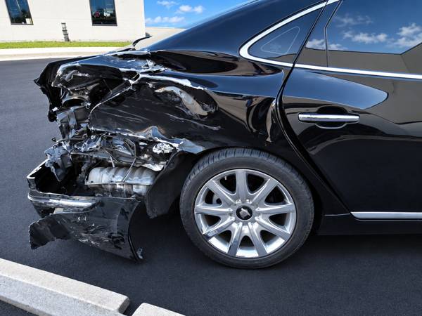 Black sedan with a crushed rear quarter panel