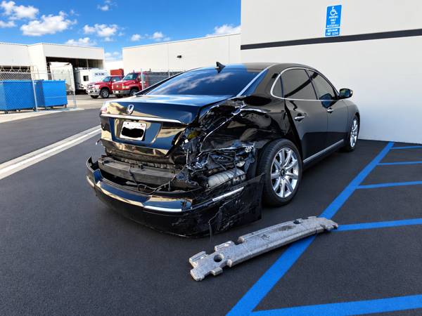Black sedan with heavy rear-end damage