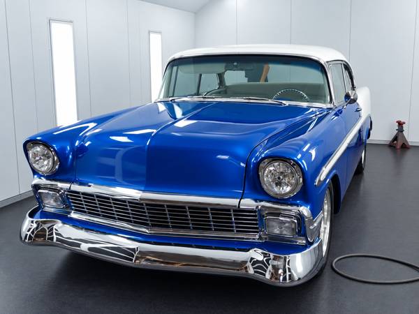 Blue classic Chevy with a white roof in the paint booth