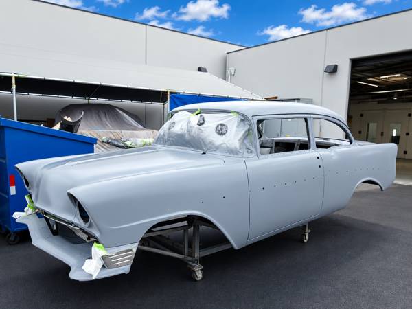 Classic car body in gray primer on a cart