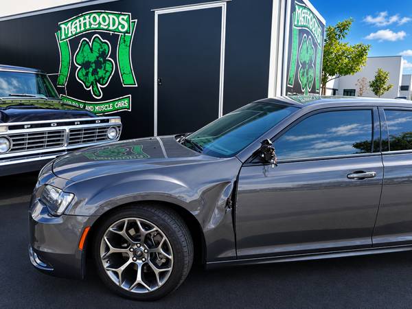 Gray Chrysler 300 next to the Mahood's shamrock trailer