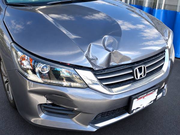 Gray Honda Accord with a dented hood and bumper