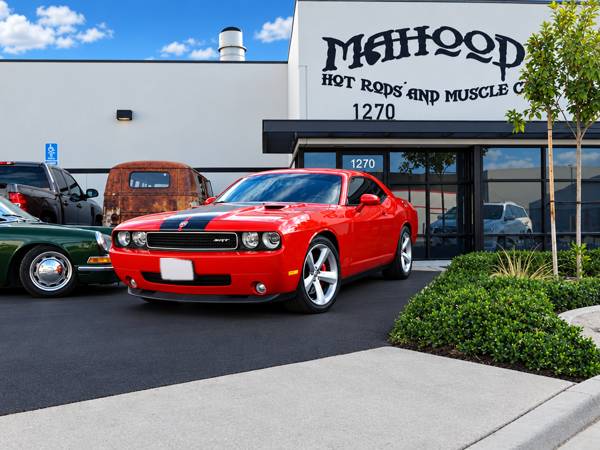 Red Dodge Challenger with a black stripe outside Mahood's