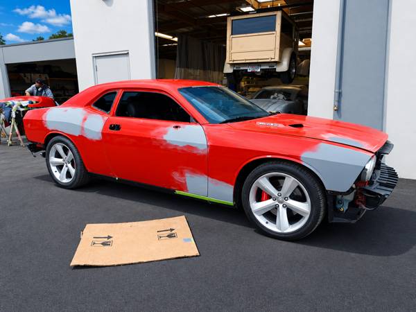 Red Dodge Challenger with panels in primer during repair