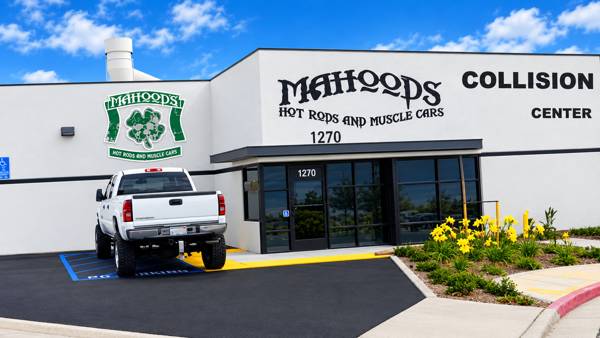 Front of the Mahood's building with the shamrock sign and collision center lettering