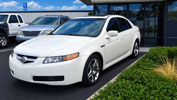 White Acura sedan in front of the shop