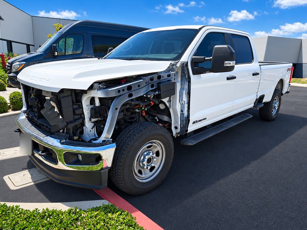 White Ford Super Duty with the fender and grille removed for repair
