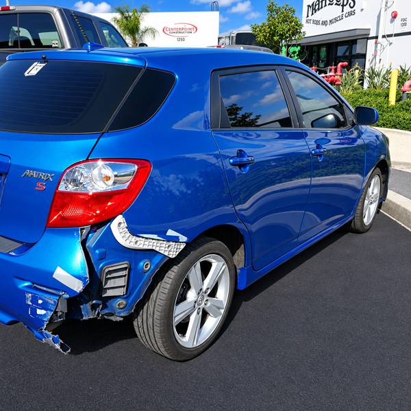 Blue Toyota Matrix with rear bumper and quarter panel damage