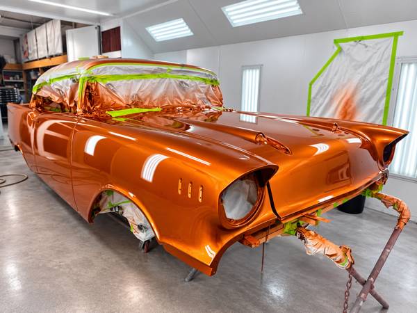 Classic Chevy with tail fins in fresh orange metallic paint in the booth